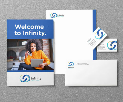 Stationery collection for Infinity Credit Union showing a Welcome folder with a smiling black female holding an ipad, a letterhead, business card and envelope sit to the right.